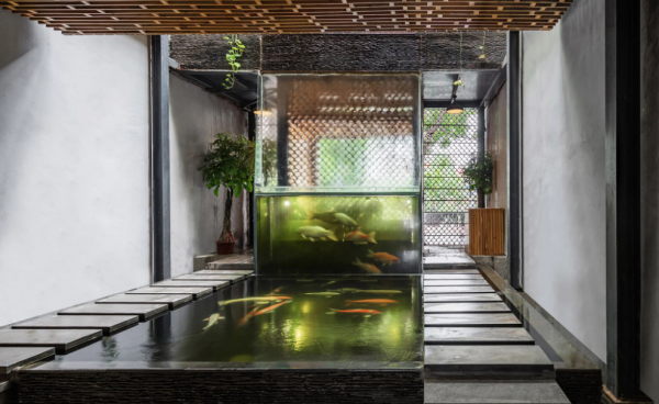 Cafe dengan area duduk yang dilengkapi dengan kolam ikan